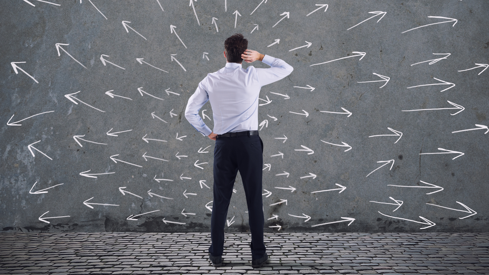 An employer, confused by arrows on a wall pointing in different directions, symbolizes the challenge of making hiring decisions amidst conflicting economic news.