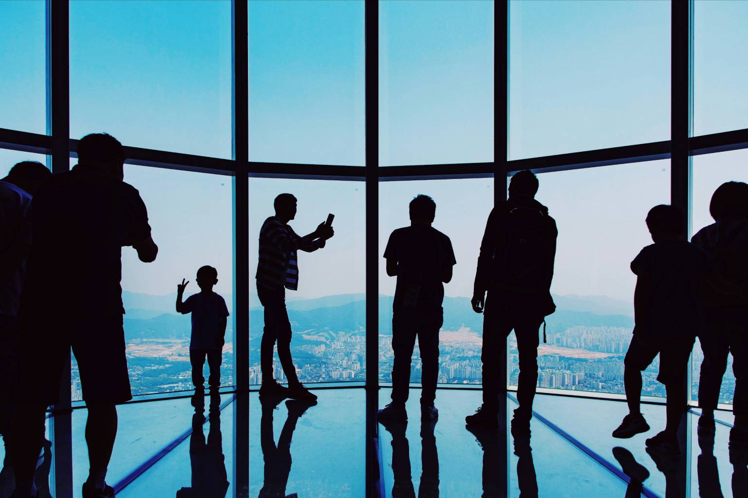Silhouettes of people inside a high-rise observation deck overlooking Los Angeles, symbolizing the top benefits of executive search firms.