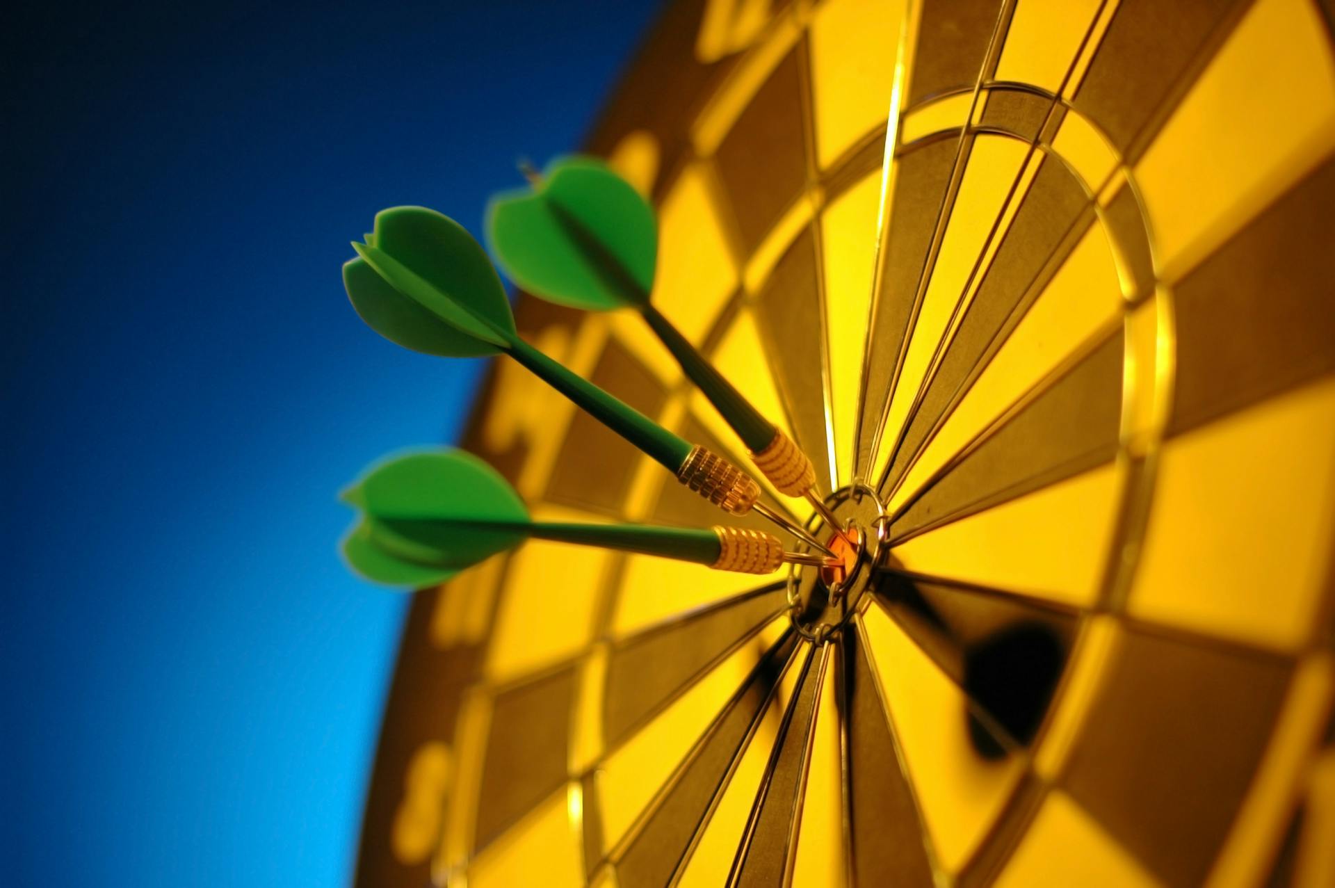 Darts hitting the bullseye on a dartboard, symbolizing precision in executive hiring decisions.