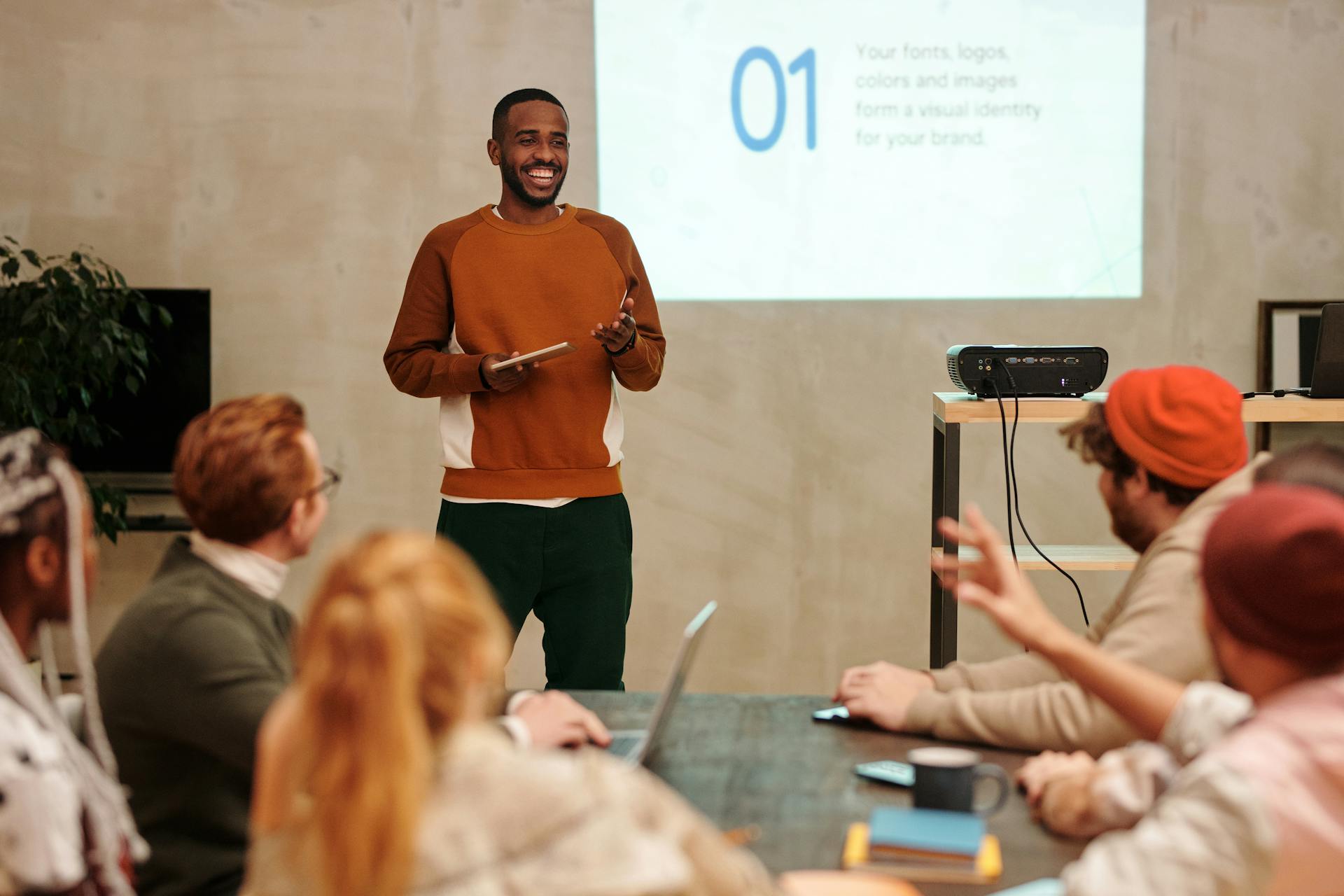 Team leader presenting to a diverse group, emphasizing culture and alignment in a modern workplace setting.