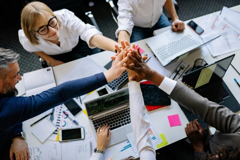 Team of modern and diverse professionals collaborating on leadership strategy, joining hands.